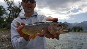 3RM Owner Mike Rivers smiling and holding a fish he caught in a Montana river