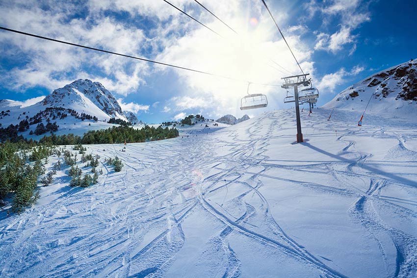 Ski chairlift at midday with blue skies and fresh powder